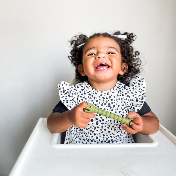 Organic Dot Flutter Bapron for babies, angled view showcasing its playful design and eco-friendly fabric.