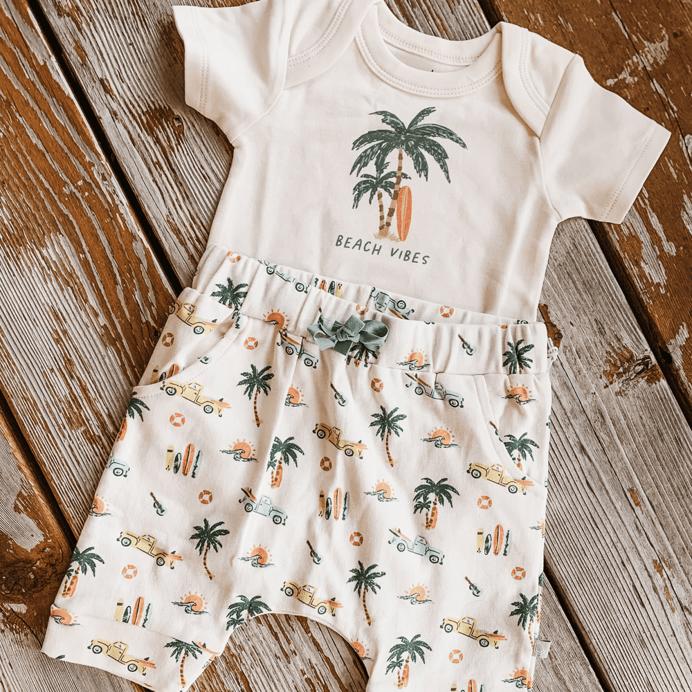 Graphic bodysuit with beach vibes and palm print for babies, perfect for summer fun. Short sleeve design.