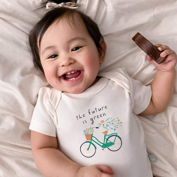Graphic short sleeve bodysuit for babies featuring "Future is Green" design, angle view.