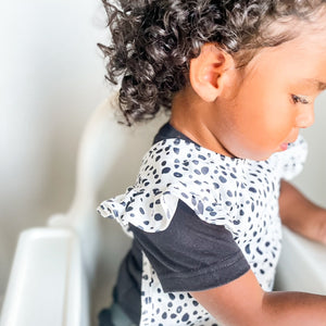 Organic Dot Flutter Bapron for babies, featuring a playful design and comfortable fit, angled view.