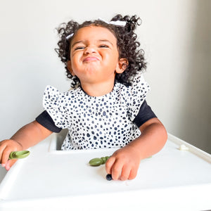 Organic Dot Flutter Bapron for babies, angled view showcasing its playful design and eco-friendly fabric.