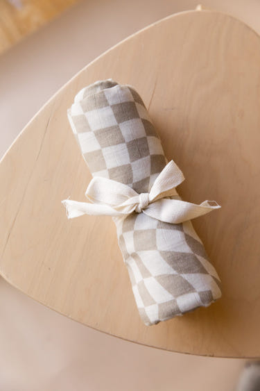 Muslin swaddle in wavy checker pattern, perfect for wrapping your baby in comfort and style.