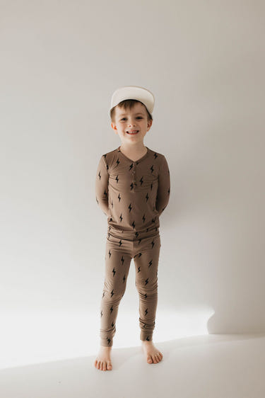 Bamboo two-piece pajamas in brown and black with lightning bolt design for babies. Soft and stylish sleepwear.