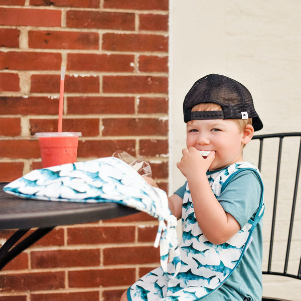 Shark Attack Bapron for babies, playful design, angled view showcasing its unique style and functionality.