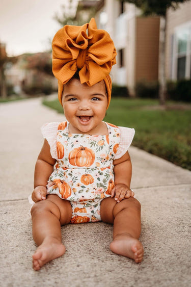 Floral pumpkin ruffle romper for babies, perfect for stylish and comfortable playtime.