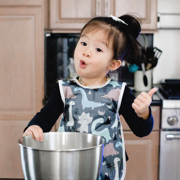 Dinosaur Drawing Bapron for babies, angled view showcasing fun design and practical use for mealtime messes.