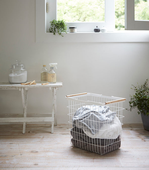 Wire basket in two sizes, featuring steel and wood design, perfect for laundry organization. Angle view 7.
