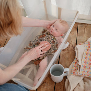 Colorful bath rinse cup for babies, angled view showcasing its ergonomic design and fun features for easy rinsing.