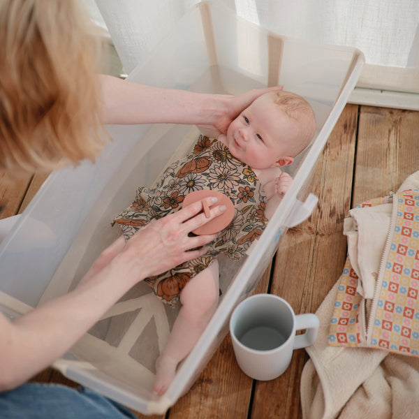 Colorful bath rinse cup for babies, angled view showcasing its ergonomic design and fun features for easy rinsing.