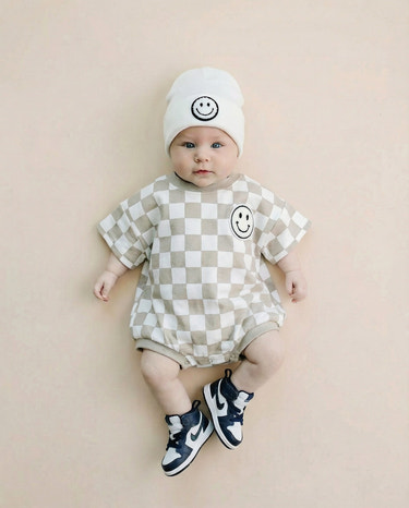 Short Sleeve Bubble Romper in Checkered Smiley Latte for babies - stylish and comfy romper for playful moments.