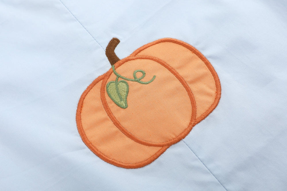 Light blue pumpkin applique overalls for babies, perfect for autumn fashion and cozy comfort.