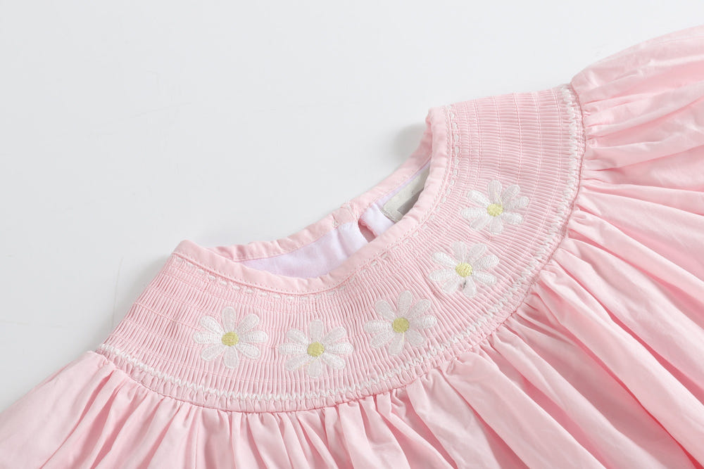 Light pink daisy smocked bishop dress for babies, perfect for special occasions and everyday wear.