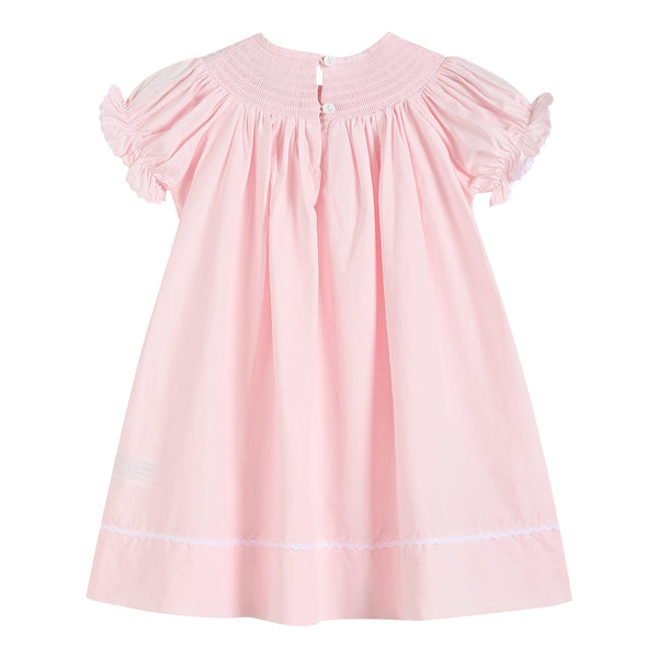 Light pink daisy smocked bishop dress for babies, angle view showcasing delicate design and soft fabric.
