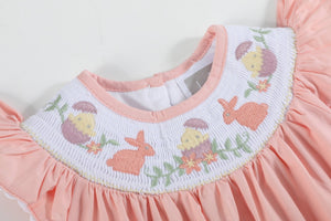 Light pink Easter smocked flutter romper for babies, showcasing a cute design from an angled view.