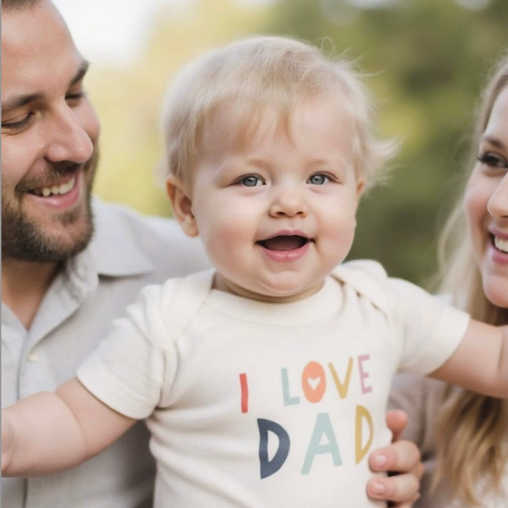 Short sleeve graphic bodysuit for babies featuring "Love Dad" design. Perfect gift for new fathers.