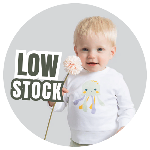 Child wearing a white sweater with a colorful design, holding a flower, on a gray background with 'LOW STOCK' text.