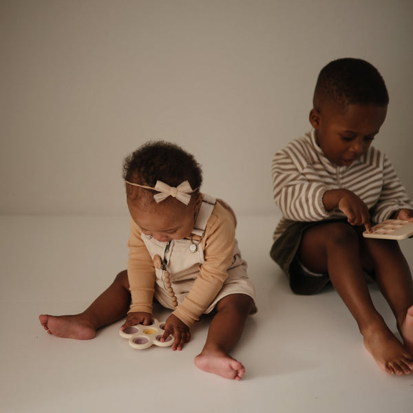 Colorful flower press toy for babies, promoting creativity and fine motor skills. Angle view showcasing vibrant design.