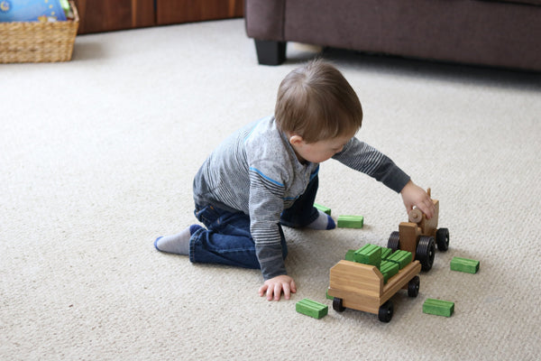 Amish-made wooden toy tractor and wagon set with hay bales for imaginative play.