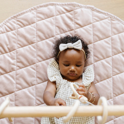 Minky play mat in soft colors, perfect for baby's playtime and tummy time, shown from an angled view.