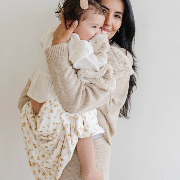Minky stretch receiving blankets in soft colors, angled view showcasing cozy texture and versatility for newborns.