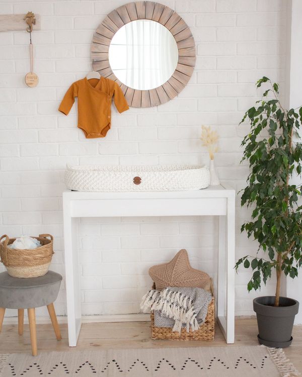 Woven baby changing basket on a dresser in a boho nursery