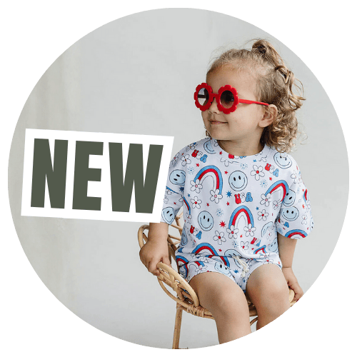 Child wearing a colorful outfit with red sunglasses and 'NEW' text on a gray background