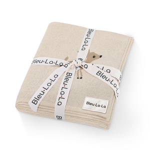 Luxury cotton deer knit swaddle baby blanket in soft hues, perfect for cozying your little one. Angle view.