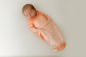 Orange Swaddle Sleep Sack from Swaddelini, perfect for keeping your baby cozy and secure during sleep.