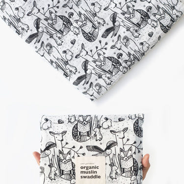 Organic muslin swaddle in forest design, perfect for keeping your baby cozy and comfortable.