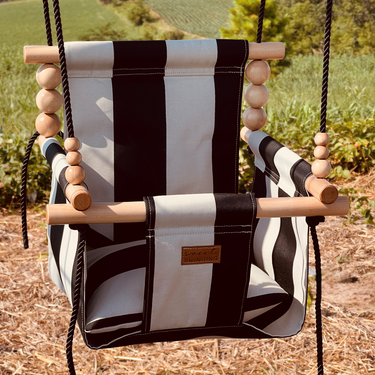 Outdoor wide cream and black stripe baby swing for comfortable and stylish playtime.