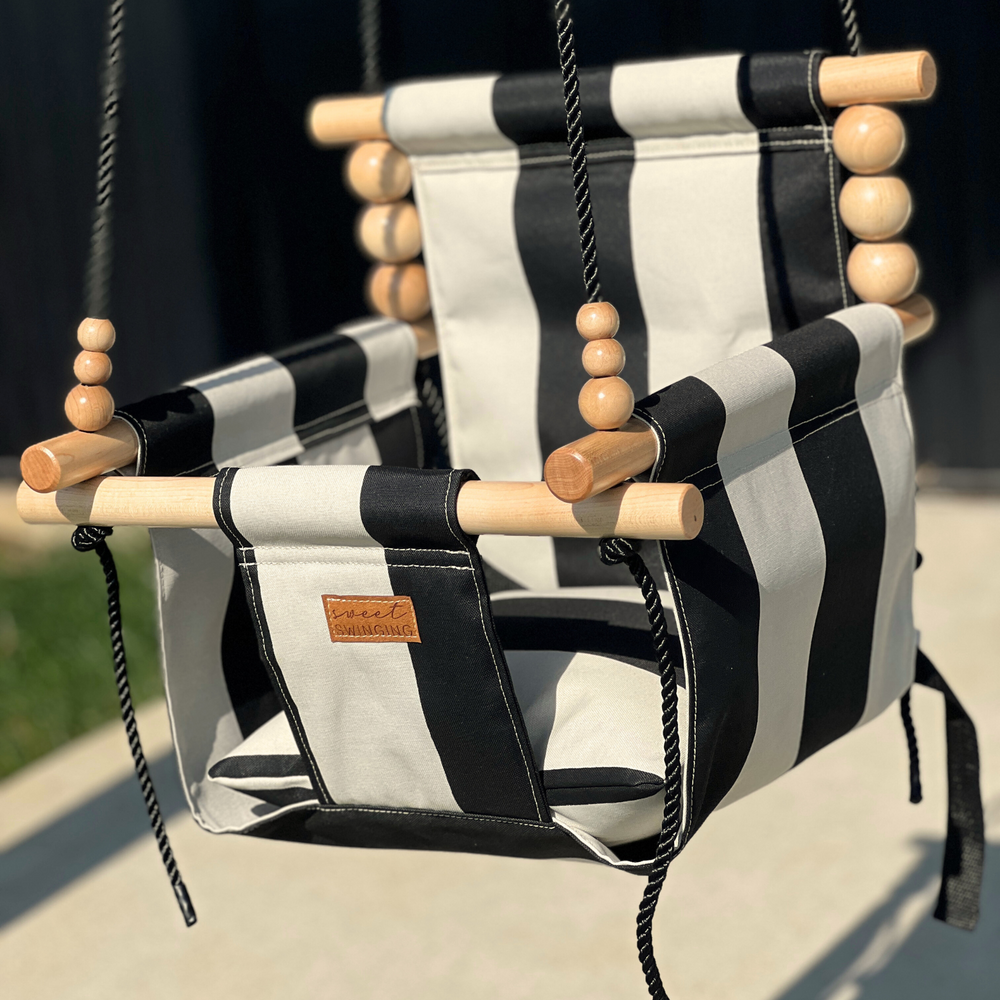 Outdoor wide cream and black stripe baby swing for comfortable and stylish playtime.