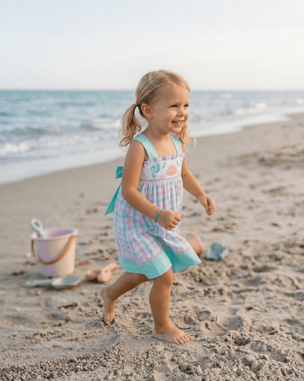 Pink and aqua seashell smocked sundress for babies, perfect for summer outings and beach days.