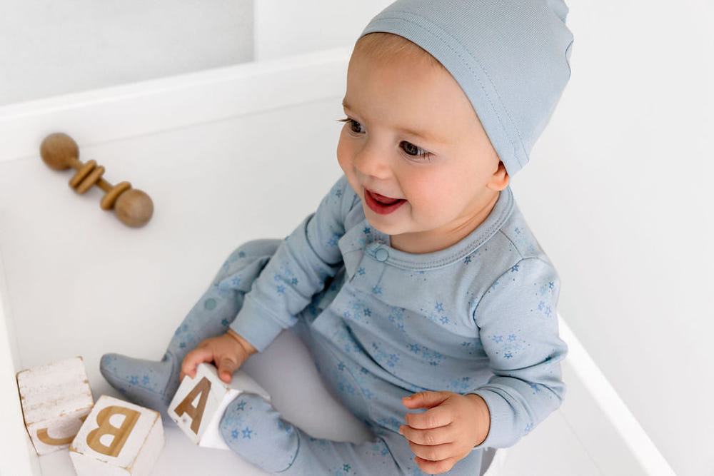 Ice blue star print footie for babies, perfect for cozy sleep and bedding.