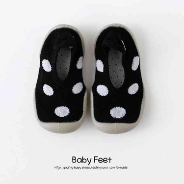 Black baby sock shoes with white spots, perfect for little feet. Stylish and comfortable footwear for infants.