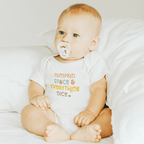 Short sleeve graphic bodysuit in pumpkin spice design, perfect for stylish baby outfits. Angle view.