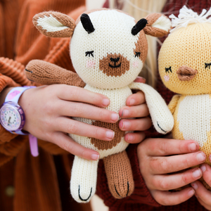 Soft plush baby goat toy, perfect for cuddling and comfort, shown from an angled view.