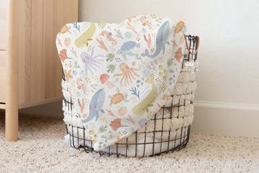 Vintage baby blanket featuring adorable ocean life animal designs for cozy comfort.