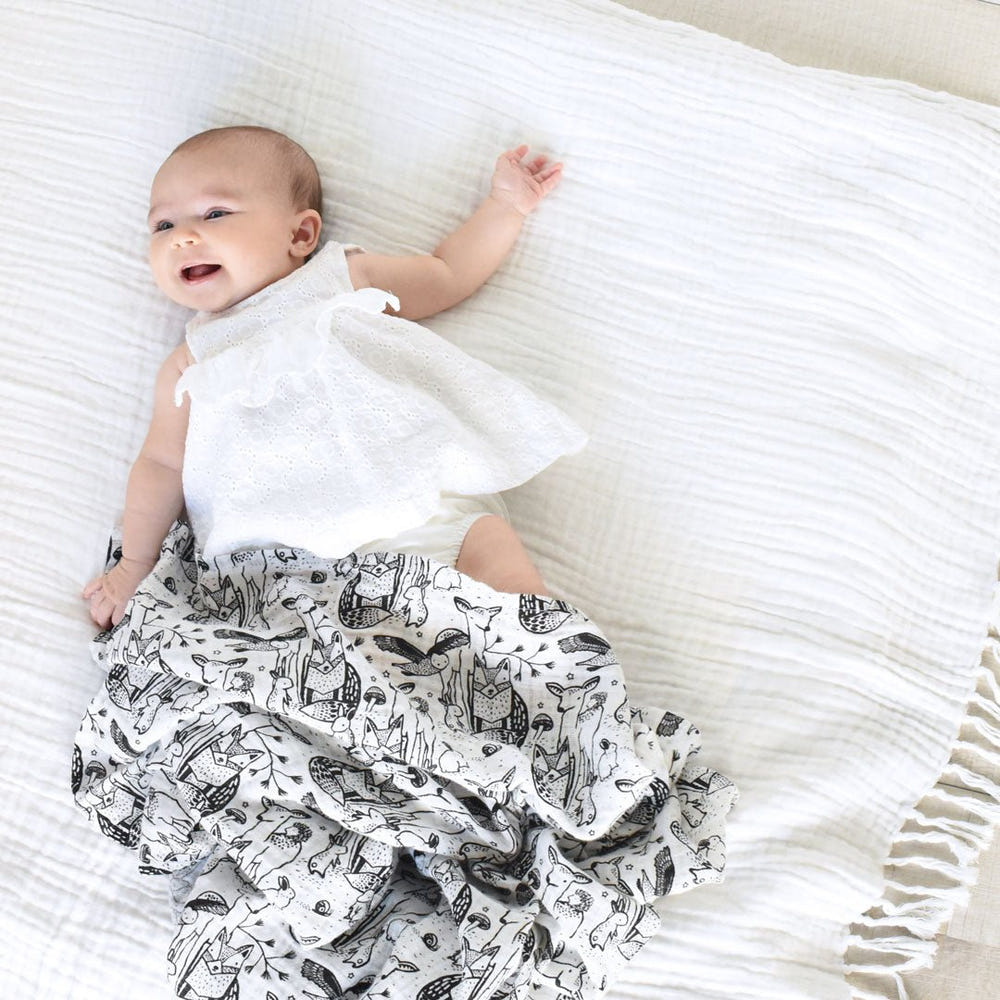 Organic muslin swaddle in forest design, perfect for keeping your baby cozy and comfortable.