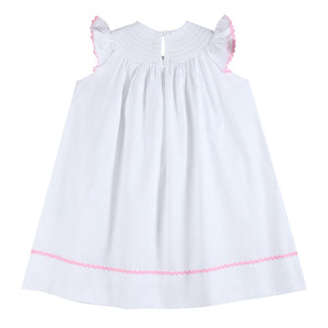 White and pink bows smocked bishop dress for babies, angle view showcasing delicate design and craftsmanship.