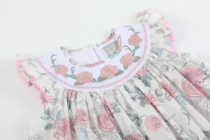 White and pink floral smocked bishop dress for babies, showcasing a charming design from angle 3.