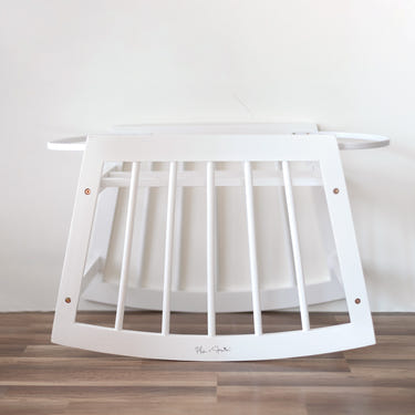Modern white rocking Moses bassinet stand with brake, perfect for safe and stylish baby sleeping.
